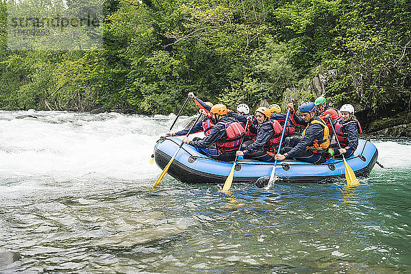 Gruppe von Menschen beim Rafting im Schlauchboot auf einem Fluss