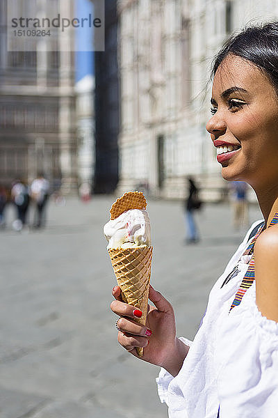 Italien  Florenz  Piazza del Duomo  glückliche junge Frau hält Eiswaffel