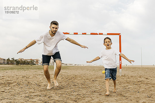 Zwei Fussballspieler feiern ein Tor am Strand