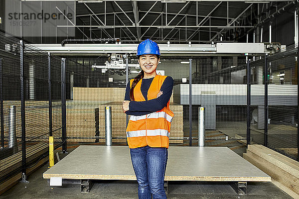 Porträt einer lächelnden Arbeiterin in einem Fabriklager