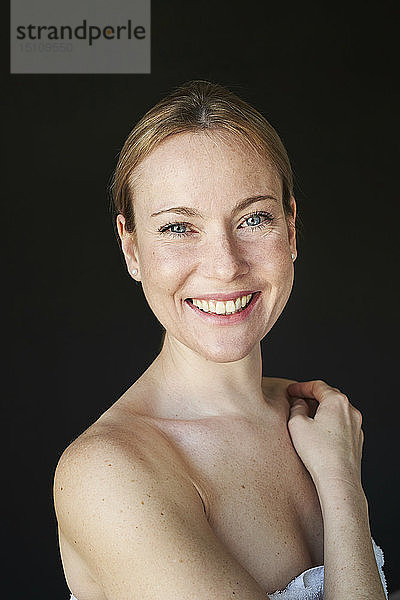 Porträt einer lächelnden Frau  trägerlos  schwarzer Hintergrund