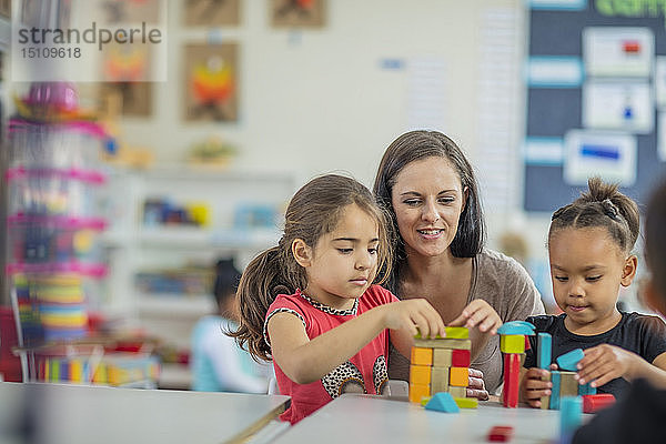 Vorschullehrerin spielt mit Mädchen im Kindergarten