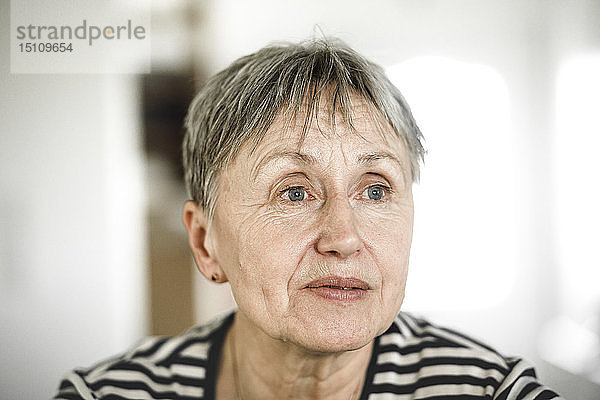Porträt einer älteren Frau mit kurzen Haaren  die wegschaut
