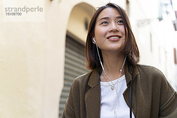 Italien  Florenz  junge Frau mit Kopfhörertelefon in der Stadt