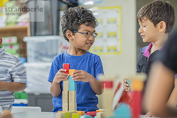 Jungen  die im Kindergarten mit Bausteinen sprechen und spielen