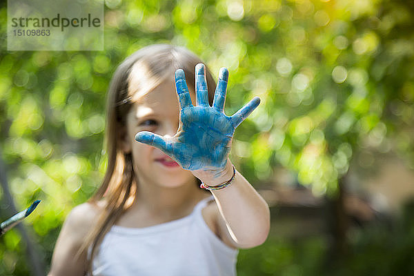 Blau gemalte Hand eines Mädchens