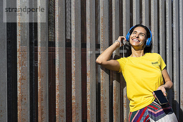 Frau mit blauen Kopfhörern beim Musikhören