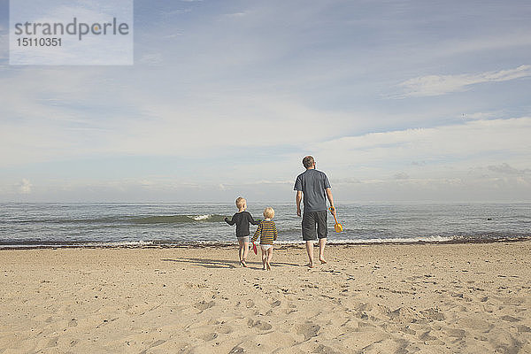Vater mit zwei Kindern am Strand