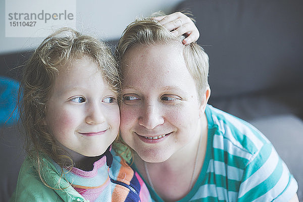 Porträt einer lächelnden Mutter mit Tochter zu Hause