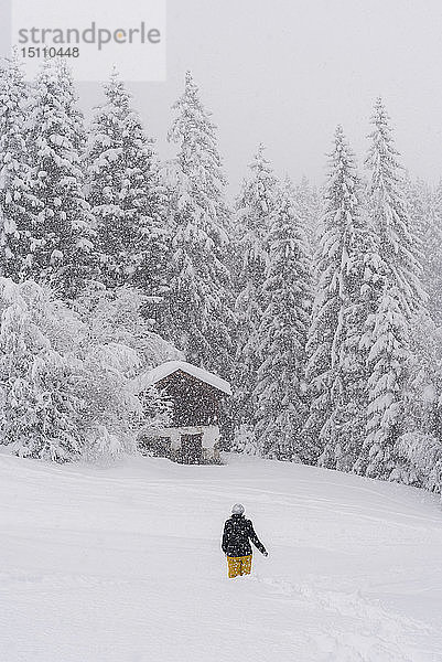 Finnland  Kuopio  Frau wandert bei Schneefall durch die Winterlandschaft