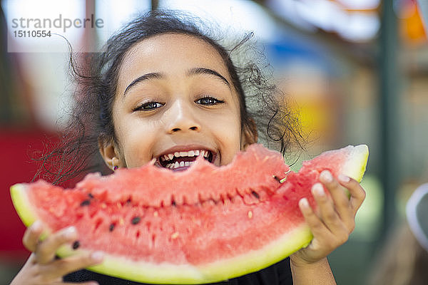 Porträt eines glücklichen Mädchens  das im Kindergarten eine Wassermelone isst