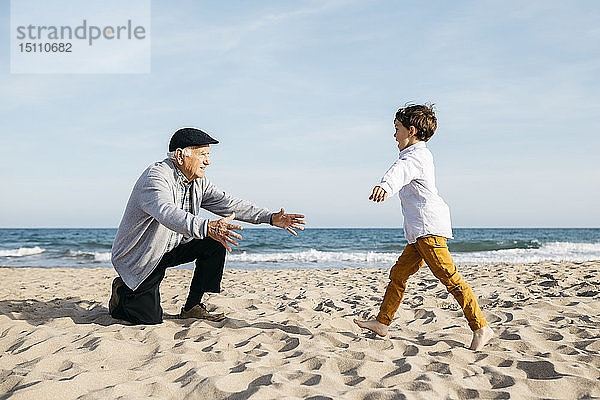 Großvater spielt mit seinem Enkel am Strand