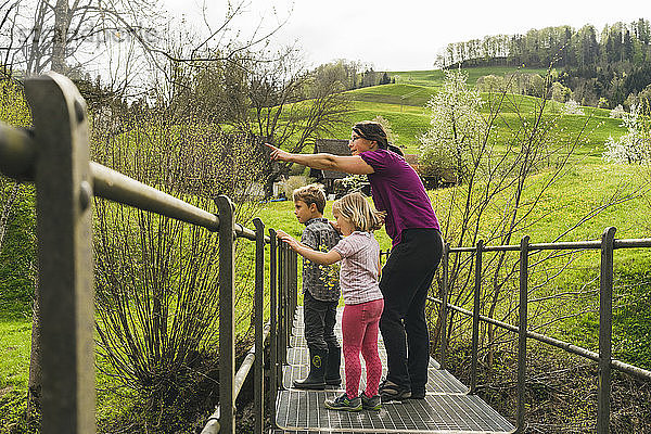 Mutter mit zwei Kindern auf einer Brücke auf dem Land