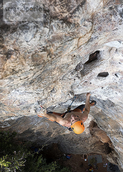 Thailand  Krabi  barbrüstiger Mann klettert in Felswand
