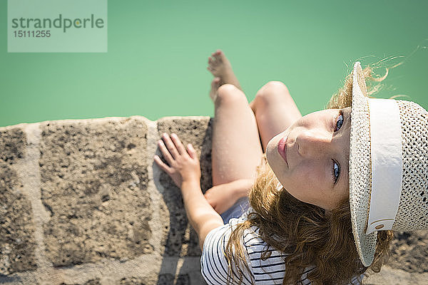 Draufsicht eines Mädchens mit Strohhut am Swimmingpool sitzend  Toskana  Italien