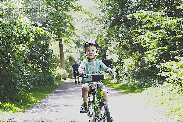 Porträt eines stolzen kleinen Jungen  der Fahrrad fahren lernt