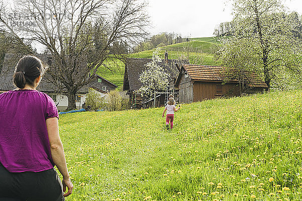 Mutter mit zwei Kindern beim Spaziergang auf der Wiese auf dem Land