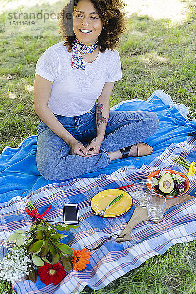 Entspannt lächelnde Frau beim Picknick im Park