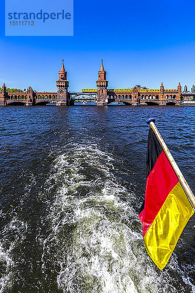 Deutschland  Berlin  Oberbaumbrücke und deutsche Flagge auf Ausflugsboot auf der Spree