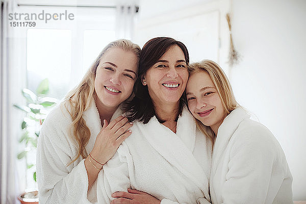 Porträt einer glücklichen reifen Frau mit zwei Töchtern in einem Badezimmer zu Hause