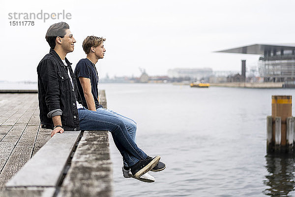 Dänemark  Kopenhagen  zwei junge Männer sitzen am Wasser