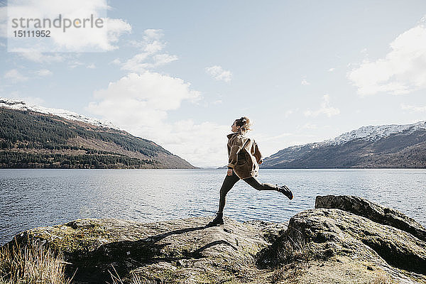 UK  Schottland  junge Frau läuft am Loch Lomond