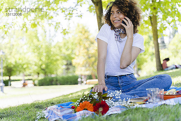 Entspannte Frau am Handy beim Picknick im Park