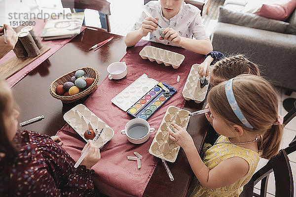 Kinder malen zu Hause Ostereier auf den Tisch