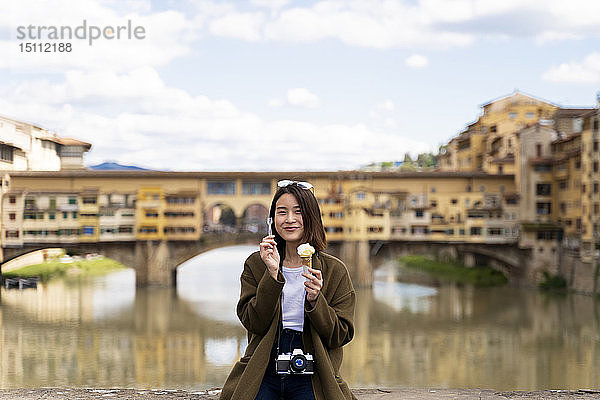 Italien  Florenz  junge Touristin beim Essen einer Eistüte in Ponte Vecchio