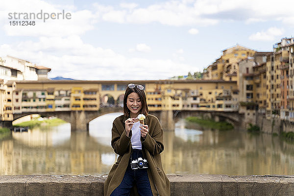 Italien  Florenz  junge Touristin beim Essen einer Eistüte in Ponte Vecchio