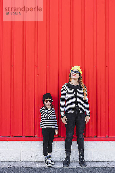 Mädchen im Teenageralter und jüngere Schwester tragen Mützen und Sonnenbrillen