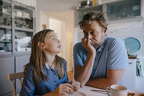 Tochter spricht zu Hause in der Küche mit dem Vater