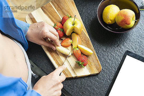 Frau hackt Früchte in ihrer Küche  Nahaufnahme