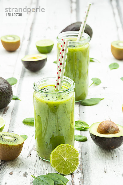 Zwei Gläser grüner Smoothie mit Avocado  Spinat  Kiwi und Limette