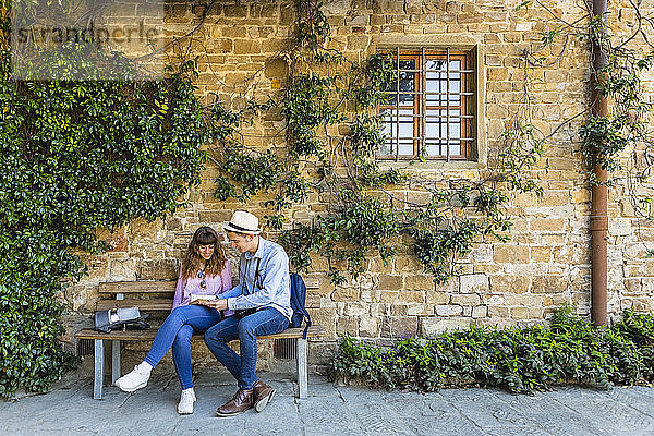 Junges Paar auf Städtereise  auf einer Bank sitzend  eine Pause machen