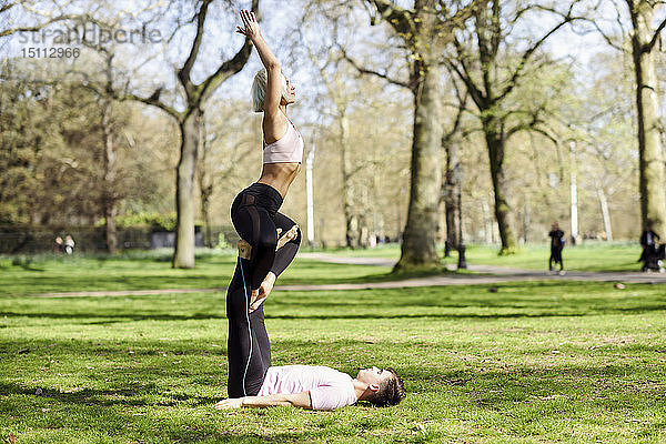 Junges Paar macht Yoga-Akrobatik in einem städtischen Park