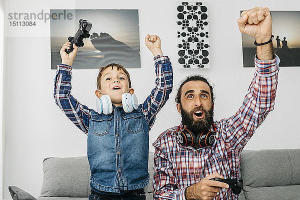 Porträt von Vater und Sohn beim Computerspiel zu Hause