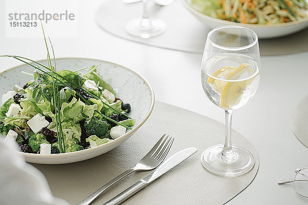 Salat und ein Glas Wasser auf einem Tisch in einem Restaurant