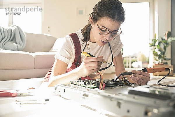 Junge Frau  die zu Hause an Computergeräten arbeitet