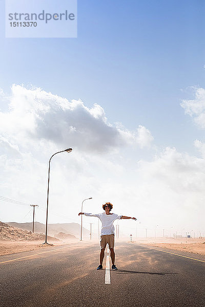 Sultanat Oman  Ras al Hadd  Wüstenstraße  Mann steht in einem Sandsturm