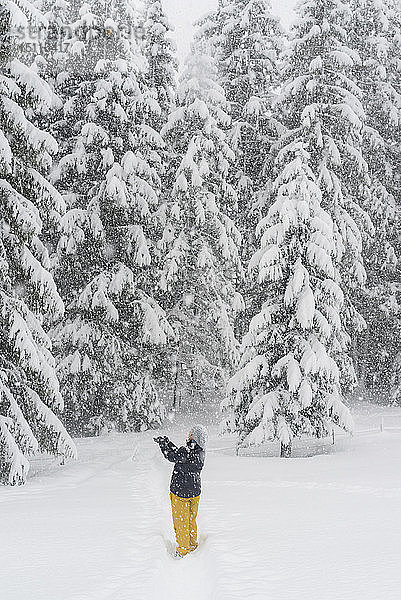 Finnland  Kuopio  Frau beim Fangen von Schneeflocken im Winterwald