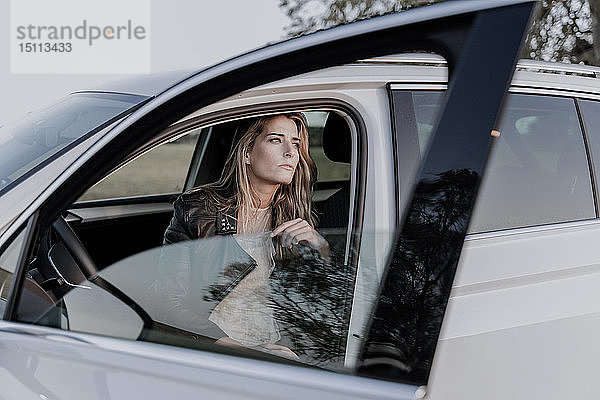 Blonde Frau sitzt in weißem Auto