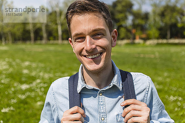 Lächelnder junger Mann in einem Park  Porträt