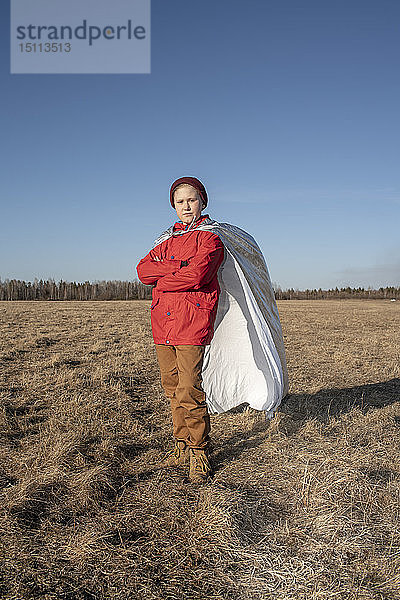 Als Superheld verkleideter Junge posiert in Steppenlandschaft