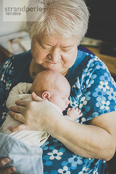 Großmutter hält ihre schlafende Baby-Enkelin