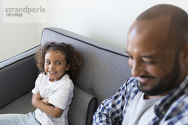 Glücklicher Vater und Tochter sitzen zu Hause auf der Couch