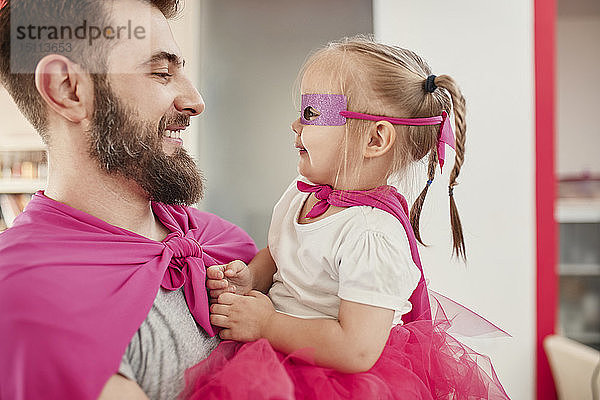 Vater und Tochter spielen Superheld und Superfrau