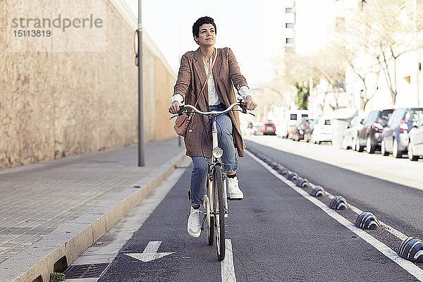 Frau mit Fahrrad auf dem Fahrradweg in der Stadt