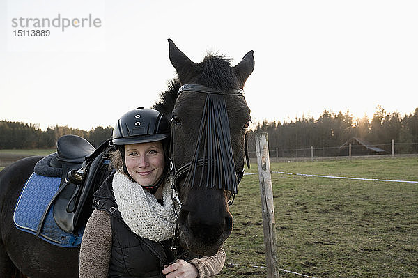 Porträt einer lächelnden Frau mit Pferd