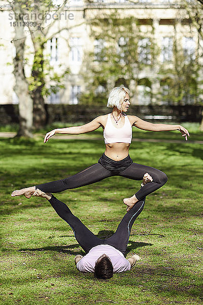 Junges Paar macht Yoga-Akrobatik in einem städtischen Park